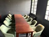 une longue table entourée de nombreuses chaises dans une pièce