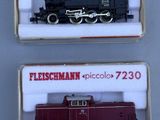 Deux trains miniatures sont exposés dans une vitrine posée sur une surface blanche.
