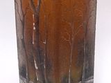 un vase en verre orné d'un motif représentant des arbres