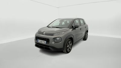 Une Citroën grise est garée dans une pièce blanche