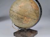 a small globe on a stand on a white surface