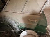 a bucket of paint sitting on the floor next to a toilet