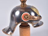 a metal elephant head on a wooden base
