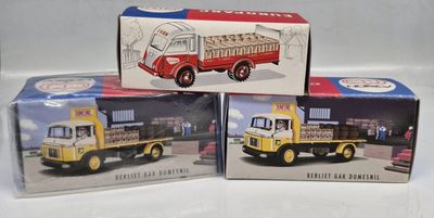three boxed boxed toys of trucks are sitting on a white surface