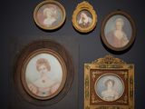 Trois portraits encadrés représentant des femmes et un homme sont accrochés au mur.