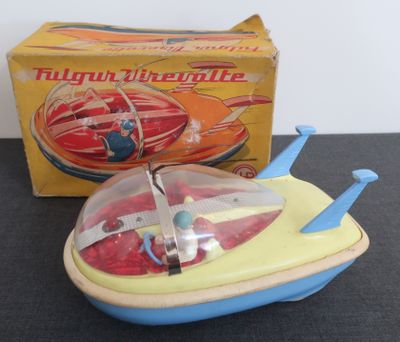 un petit bateau jouet muni d'une hélice, posé devant une boîte