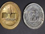 two gold and silver coins sitting side by side on a black surface