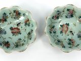 pair of chinese porcelain bowls with floral designs on them on a white surface