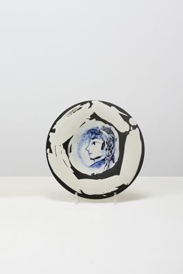 une assiette noire et blanche ornée d'une fleur bleue