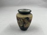 un petit vase orné d'une peinture, posé sur une surface blanche
