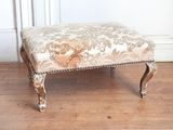 une image représentant un repose-pieds dont l'assise est recouverte d'un tissu à motifs floraux
