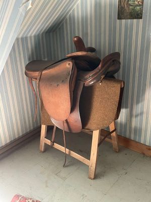 une selle posée sur un support dans un coin de la pièce