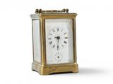 a small gold clock with roman numerals on it