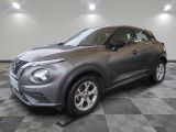 Un SUV Nissan Juke gris est garé dans un garage.