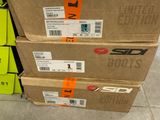 Trois cartons de chaussures sont empilés les uns sur les autres dans un magasin.