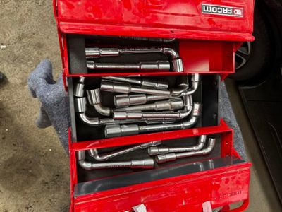 une boîte à outils rouge contenant tout un tas d'outils