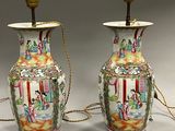 une paire de vases chinois ornés de scènes asiatiques, posés sur une table