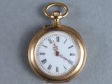 a gold pocket watch with roman numerals on it