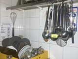 Des casseroles et des poêles sont suspendues à un support dans une cuisine.
