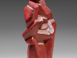 a red sculpture of a woman holding a child