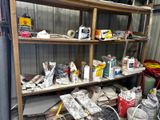 a shelf full of paint and other items in a garage