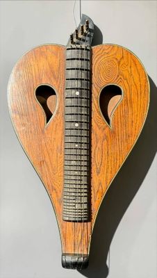 a wooden heart shaped instrument hanging on the wall