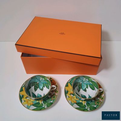 deux tasses et soucoupes avec une boîte posées sur une table