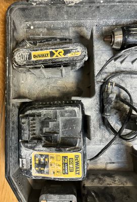 une photo d'une boîte à outils contenant une perceuse filaire et deux batteries
