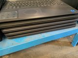 a stack of laptops sitting on top of a blue table