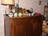 une armoire en bois sur laquelle sont posés un miroir et une lampe