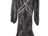 une photo d'une robe à pois noirs et blancs suspendue à un cintre