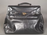 black leather backpack with gold buckles on the front