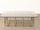 an image of a glass and brass coffee table on a concrete floor