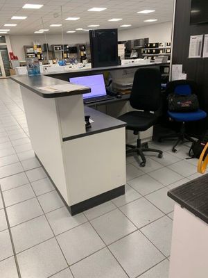 un bureau d'ordinateur sur lequel est posé un ordinateur portable, dans une bibliothèque