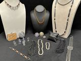 many different necklaces and bracelets on display on a table