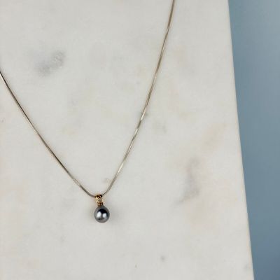une photo d'un collier orné d'une perle noire