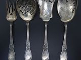 quatre cuillères et une fourchette sont alignées sur un fond noir