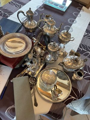 une table sur laquelle sont disposés plusieurs assiettes et couverts en argent