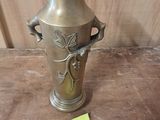 a gold vase sitting on a table with a price tag on it