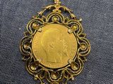 un pendentif en forme de pièce d'or sur lequel est représenté un homme
