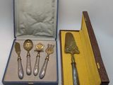 four silverware items in a case on a table