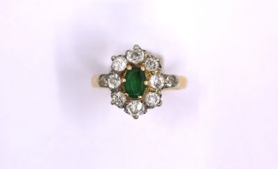 a close up of a green and white diamond ring on a white surface