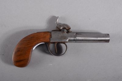 un vieux pistolet avec une poignée en bois sur une surface blanche