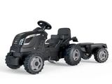 un tracteur jouet noir avec une remorque, sur fond blanc