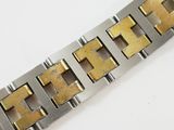 a close up of a metal bracelet on a white surface