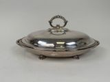 an antique silver plate with a domed lid on a stand