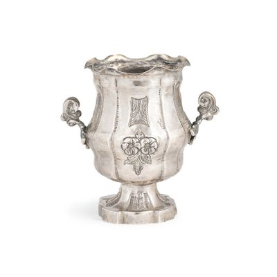 un vase en argent posé sur une surface blanche