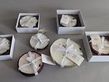 six white boxes with different types of candles in them sitting on a table