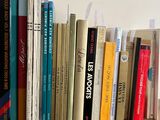 many books that are on a wooden shelf