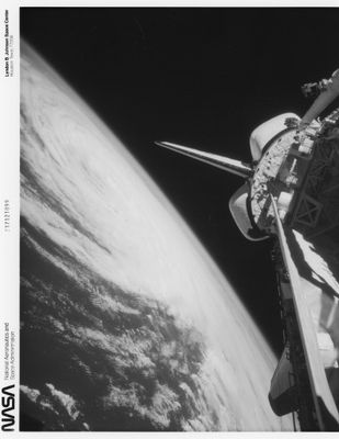 photographie en noir et blanc d'une navette spatiale en orbite, avec la Terre en arrière-plan
